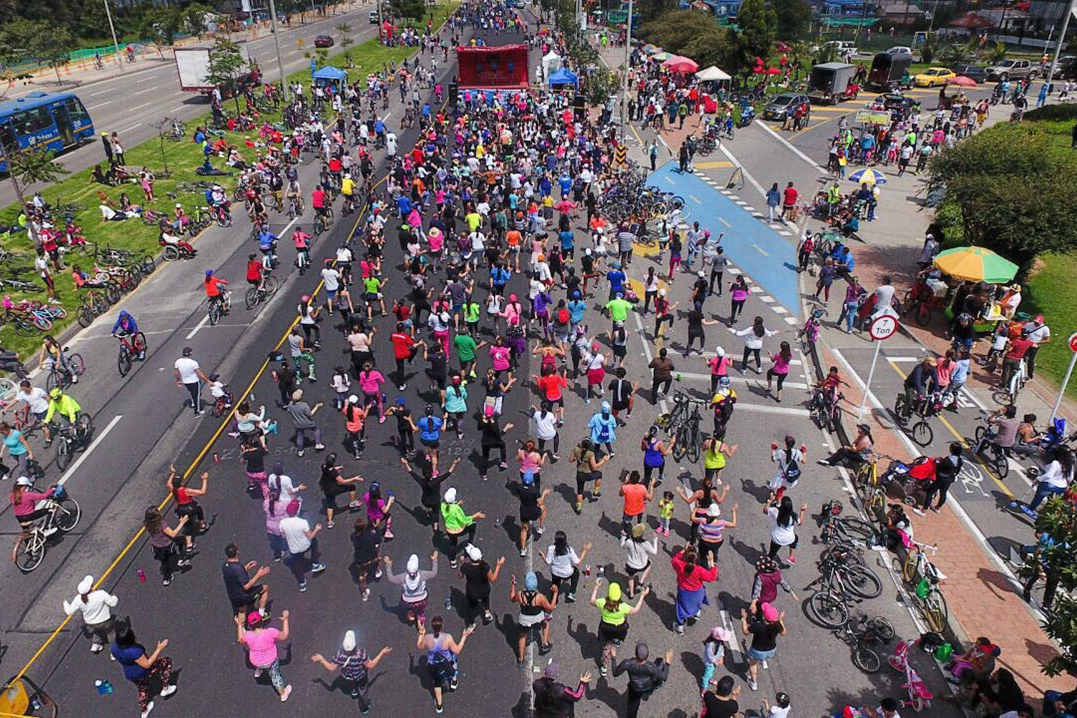 Tausende Menschen tanzen vor einer Bühne auf der Ciclovía in Bogotá